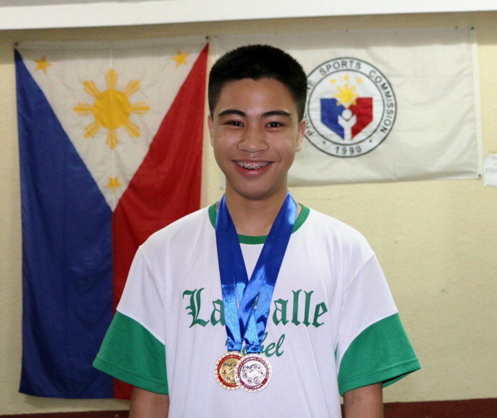 Enrique proudly wears his Lasallian shirt with the medals he won during the 2014 National Open shooting championships.
